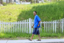 Hombre con lesión cerebral traumática relajándose con su bastón en su vecindario - foto de stock