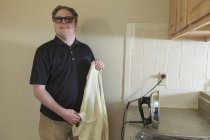 Man with congenital blindness ironing his shirt at home — Stock Photo