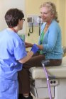 Медсестра с церебральным параличом проверяет пульс пациента в клинике — стоковое фото