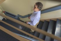 Людина з вродженою сліпотою, використовуючи свою тростину, щоб спуститися вниз по сходах — стокове фото
