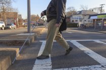 Man with congenital blindness crossing the street using his cane — Stock Photo