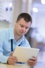 Man with down syndrome working in area of hospital — Stock Photo
