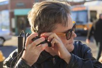 Uomo con cecità congenita che utilizza la tecnologia assistiva per ascoltare per strada — Foto stock