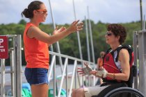 Женщина с травмой спинного мозга разговаривает с инструктором об использовании каяка — стоковое фото