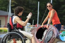 Donna con una lesione del midollo spinale parlare con un istruttore di utilizzare un kayak — Foto stock