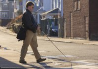 Людина з вродженою сліпотою, що переходить вулицю, використовуючи свою тростину — стокове фото