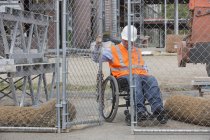 Engenheiro de projeto com uma lesão medular em uma cerca de fechamento de cadeira de rodas para o local de trabalho — Fotografia de Stock