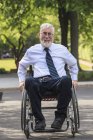 Homme d'affaires atteint de dystrophie musculaire en fauteuil roulant — Photo de stock