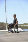 Homme en fauteuil roulant qui avait une méningite rachidienne sur un quai à voile — Photo de stock