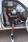 Hombre que tenía meningitis espinal subiendo a su vehículo accesible - foto de stock