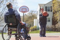 Pai e filho com síndrome de Down jogando no basquete — Fotografia de Stock
