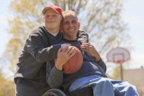 Отец и сын с синдромом Дауна играют в баскетбол — стоковое фото