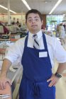 Людина з синдромом Дауна працює в продуктовому магазині — стокове фото