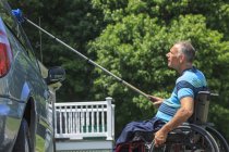 Mann mit Querschnittslähmung im Rollstuhl wäscht sein behindertengerechtes Auto — Stockfoto