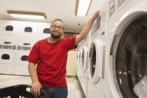 Afro-americano com Síndrome de Down para lavanderia em sala de serviço — Fotografia de Stock
