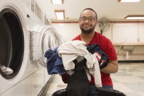 Uomo afroamericano con sindrome di Down per lavanderia in ripostiglio — Foto stock