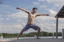 Young man with Down Syndrome exercising on a dock — Stock Photo