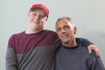 Батько з ураженням спинного мозку і сином з синдромом Дауна разом вдома — стокове фото