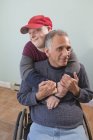 Padre con lesión de médula espinal e hijo con síndrome de Down juntos en casa - foto de stock