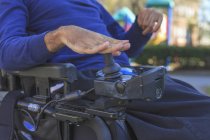 Uomo afroamericano con paralisi cerebrale utilizzando la sua sedia a rotelle potere al di fuori — Foto stock