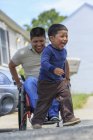 Uomo ispanico con lesione del midollo spinale in sedia a rotelle a giocare con suo figlio — Foto stock