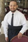Portrait of African American man with Down Syndrome as a waiter in restaurant — Stock Photo
