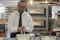 Afrikanisch-amerikanischer Mann mit Down-Syndrom kocht als Koch in der Großküche — Stockfoto
