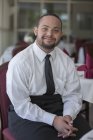 Ritratto di uomo afroamericano felice con sindrome di Down come cameriere nel ristorante — Foto stock
