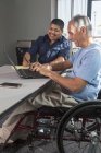 Zwei Männer mit Querschnittslähmung arbeiten in einem Büro — Stockfoto