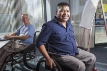 Due uomini con lesioni al midollo spinale che lavorano in un ufficio — Foto stock