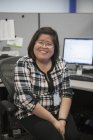 Retrato de mulher asiática feliz com uma deficiência de aprendizagem sorrindo no escritório — Fotografia de Stock