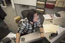 Mulher asiática com uma deficiência de aprendizagem trabalhando em seu computador no escritório — Fotografia de Stock
