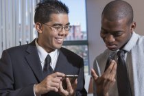 African American man and Asian with Autism working in office — Stock Photo