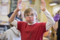 Niño con síndrome de Down en un aula escolar - foto de stock
