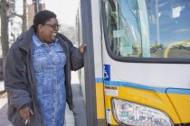 Mujer con trastorno bipolar a punto de tomar un autobús y fumar - foto de stock