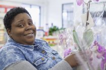 Retrato de una mujer feliz con trastorno bipolar comprando flores - foto de stock