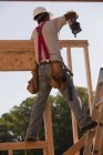 Carpenter nailing wall frame at building construction site — Stock Photo