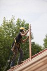 Falegname ispanico che trasporta un pannello di particelle in una casa in costruzione — Foto stock