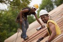 Carpenters working on the roof of a house under construction — Stock Photo