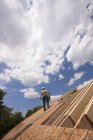 Falegname ispanico che cammina sul tetto di una casa in costruzione — Foto stock