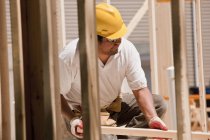 Tischler platziert Mauerstecker auf einer Baustelle — Stockfoto