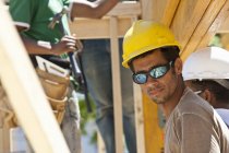Carpinteros preparando viga laminada en una obra de construcción - foto de stock