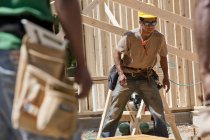Плотники, работающие над каркасным домом на строительной площадке — стоковое фото