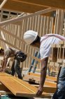 Zimmerleute messen Balken auf einer Baustelle — Stockfoto