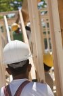 Плотники поднимают балку на строительной площадке — стоковое фото