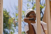 Carpenter using framing hammer on a house frame — Stock Photo
