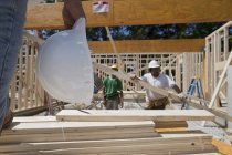 Carpinteiros enquadrando uma casa em um canteiro de obras — Fotografia de Stock