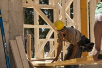 Плотники поднимают балку на строительной площадке — стоковое фото