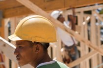 Carpenters in a framed house at a building construction site — Stock Photo