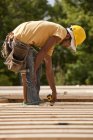 Carpenter measuring wood at a building construction site — Stock Photo